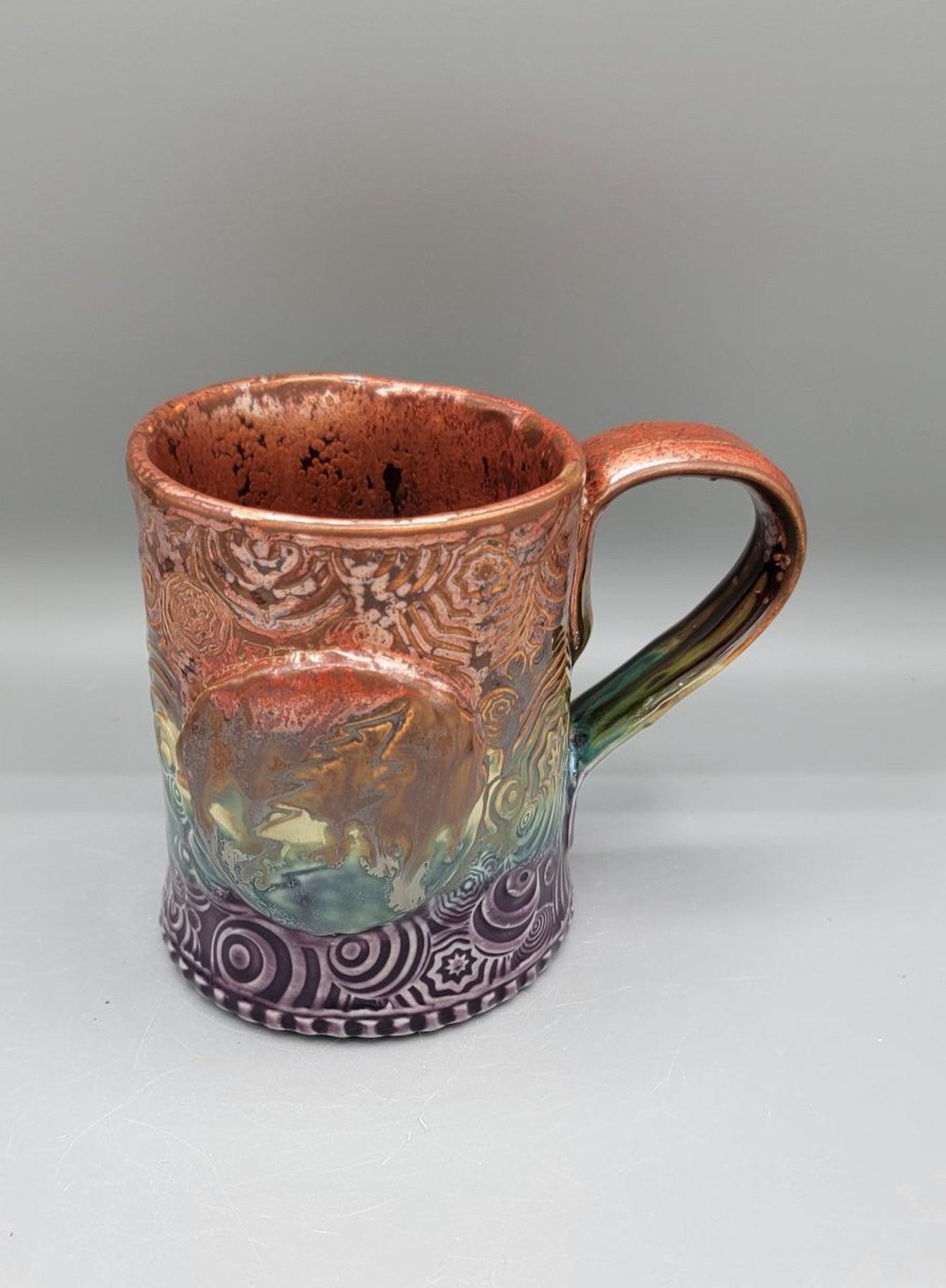 14-15 oz Embossed Trippy Circles Mug with Bolt Medallion in Melting Copper to Purple